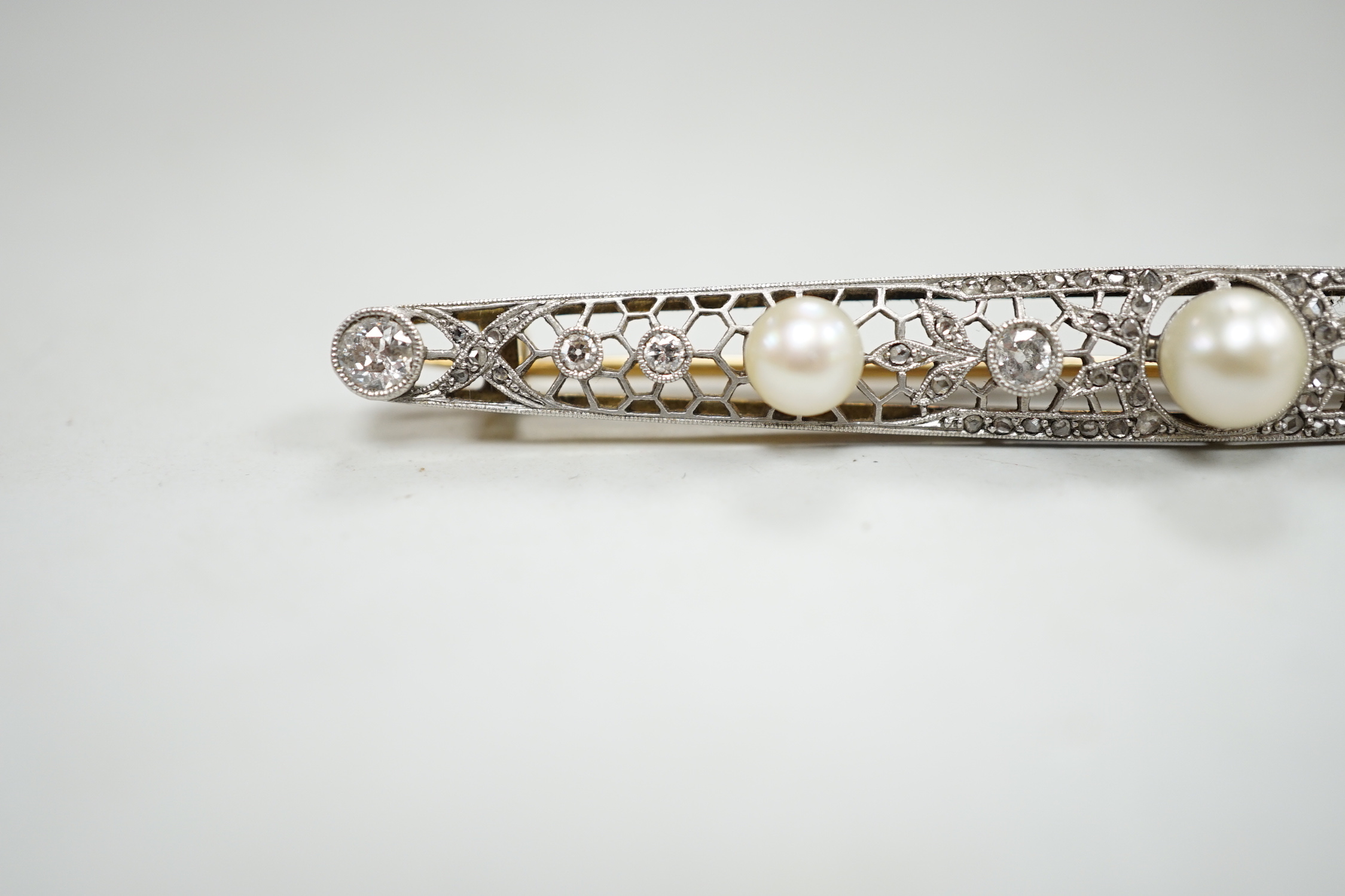 A Belle Epoque pierced yellow and white metal, cultured? pearl and diamond set bar brooch, 84mm, gross weight 10 grams, in fitted leather box.